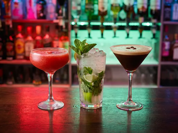 Illustration of cocktails lined up on a bar under neon light
